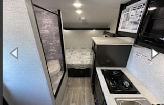 Yes it has a bathroom. Small easy to tow 3200lbs.