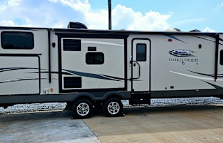Large RV with outdoor kitchen, fireplace, and TVs