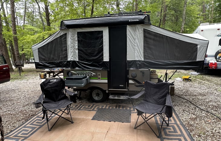 Exterior with outdoor area rug, two camp chairs, outdoor stove, awning and exterior speakers w/ bluetooth radio
