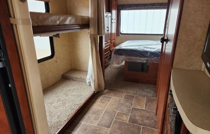 The cubby on the floor here is where the 2nd fridge sits, this is a slide out. The top is bunk, windows both open and have window shades.