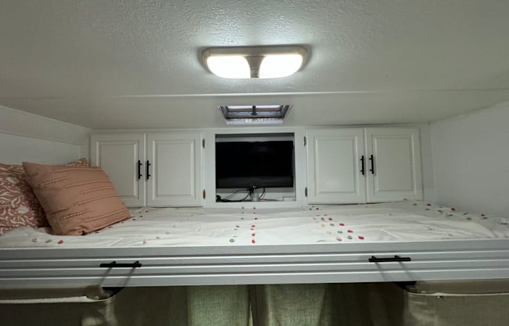 Extra long twin above driver and passenger seat with extra blanket storage.