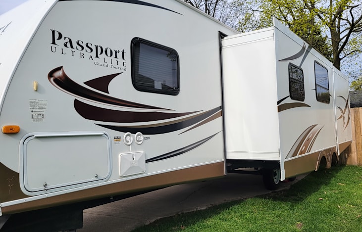 Driver's side view with storage, outdoor shower, super slide in living room/dining room & back bedroom slide.