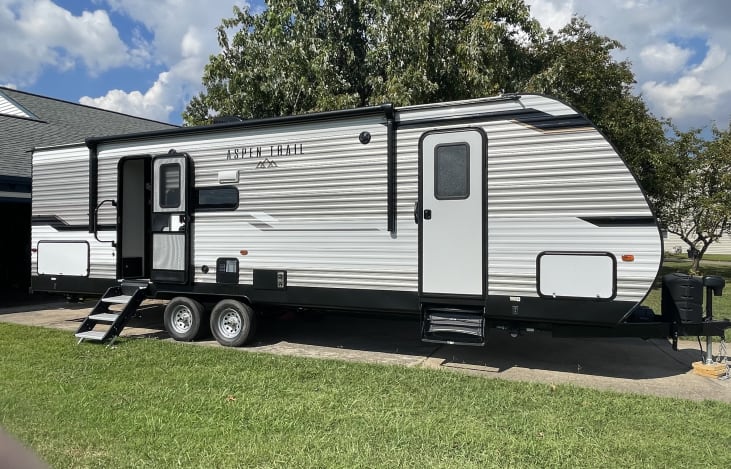 Comes with large outdoor rug, which is placed under the steps to the interior, outside stove top, and exterior storage with outdoor games and 4 chairs.