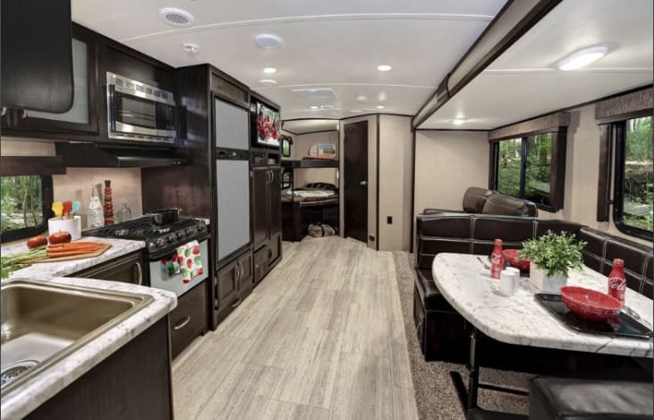 Kitchen and Main Living area with bunks displayed in the background.