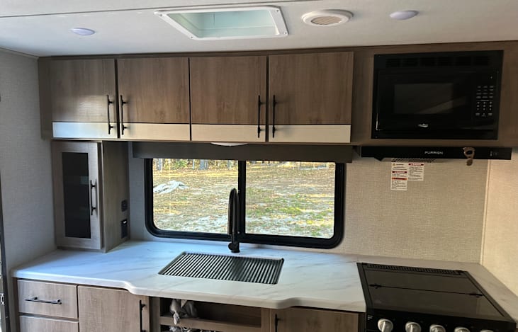 All the conveniences of a home kitchen hot and cold water on demand, 3 burner gas burners, oven, microwave and cool fridge and freezer.