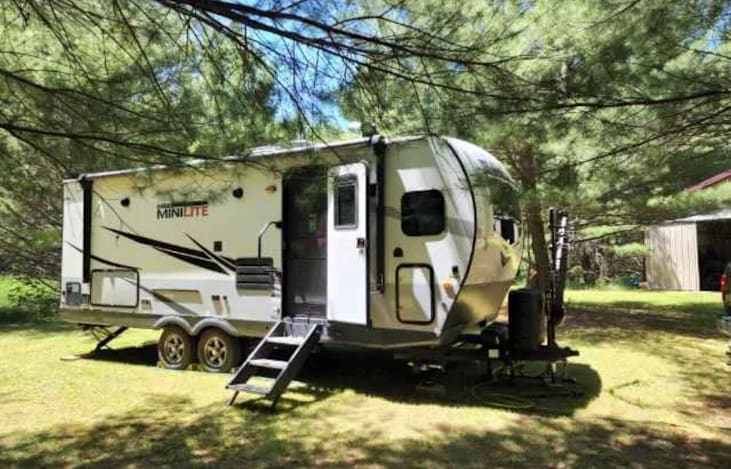 Large electric awning makes it easy to open and close  without effort.  There is an outdoor refrigerator and small griddle to cook on.