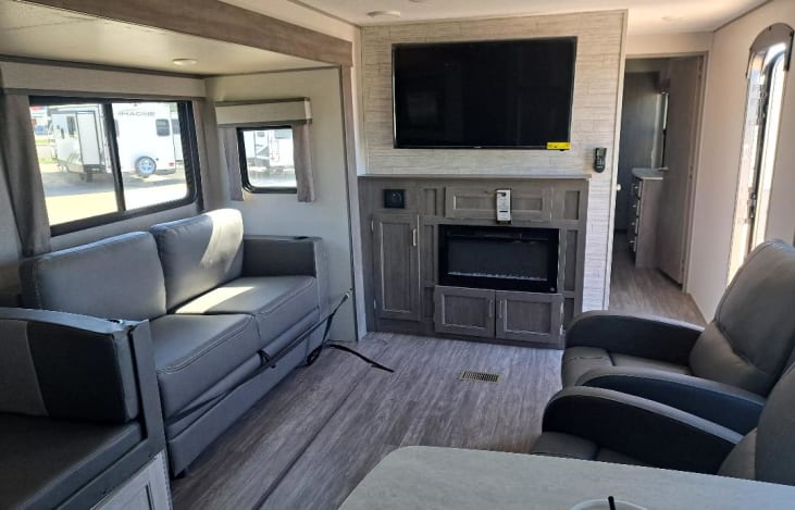 Living room with smart TV, sound system, fireplace,2 recliners and the kids sofa sleeper and dining table converts to bed.