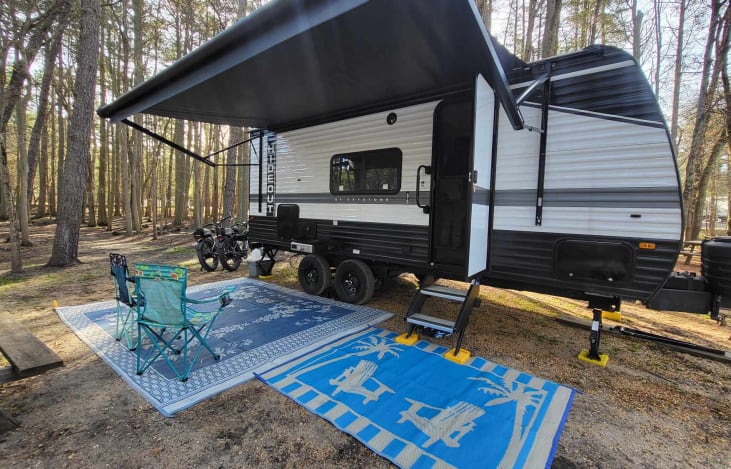 Camper with awning and the two mats provided