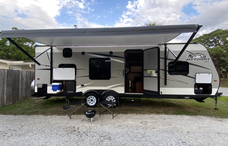 The 13' Electric Awning, LED Awning Accent Light, 2 Provided Camping Chairs, Outside Cocktail Bar, and Provided BBQ Grill make for an excellent camping experience.