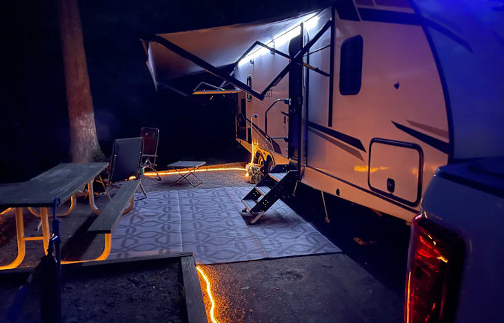 Rope light can be used on the ground to surround your site.  Outdoor rug is also included in the storage compartment with 2 lawn chairs.