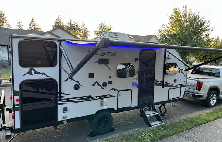 Canopy out with LED lighting, access to an outdoor fridge, and a wall mount for external tv with speakers, power, and antenna connection.