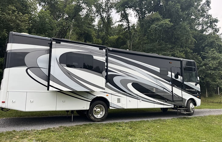 Sleek exterior with bold graphics, built-in awning, LED lighting, and outdoor TV—perfect for relaxing, tailgating, or enjoying movie nights under the stars in style and comfort.