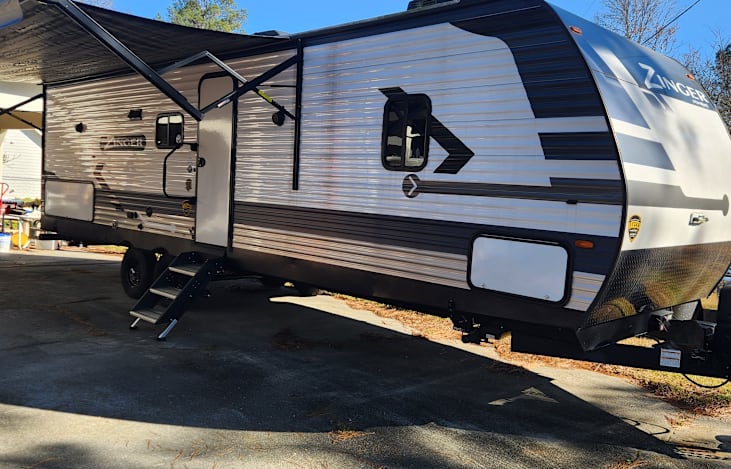 Front showing awning, outside kitchen access and pass through storage access.