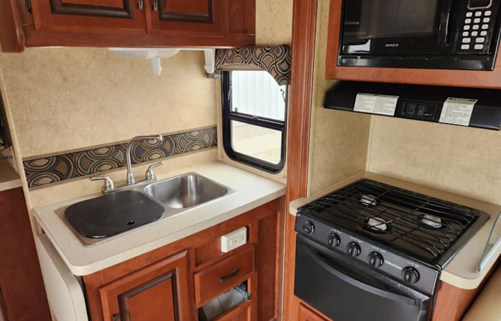 Stove and oven are gas, the sink has both hot and cold water. We have attached a rack for spices, a knife block and container to hold larger serving utensils. Microwave works great also.