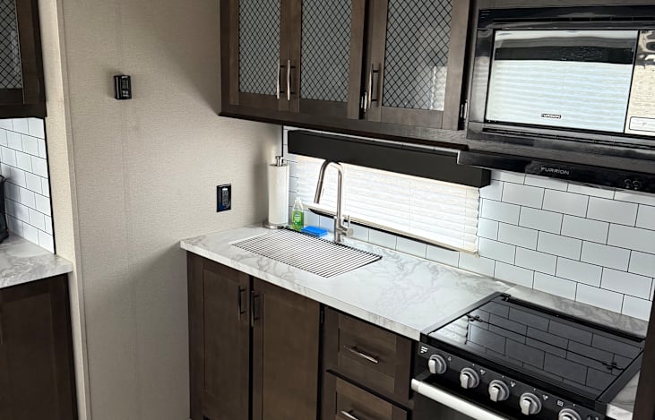 Full kitchen. 3 burner gas range with stove below.