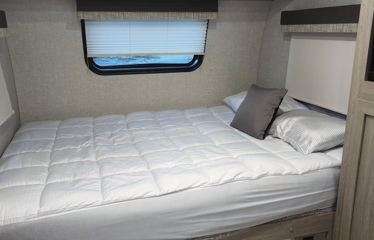 Queen bed with mattress topper.
