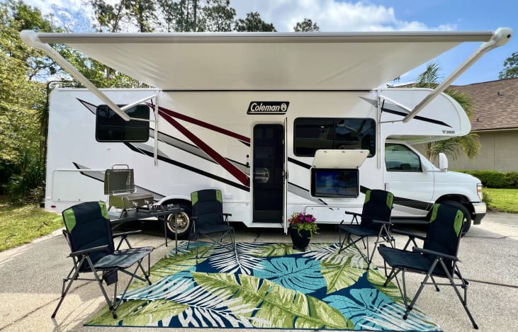 Outdoor setup - 4 chairs, outdoor rug, folding table, outdoor TV, 14 foot motorized awning and (optional add-on) gas grill.
