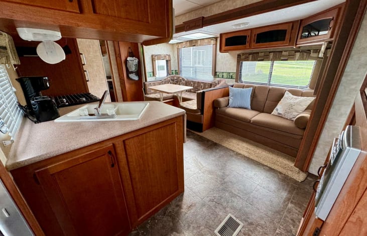 Main entrance to the camper. Couch and dinette are visible with the kitchen area on the left.