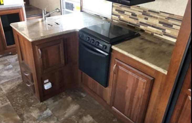 Inside kitchenette stove and small range top.