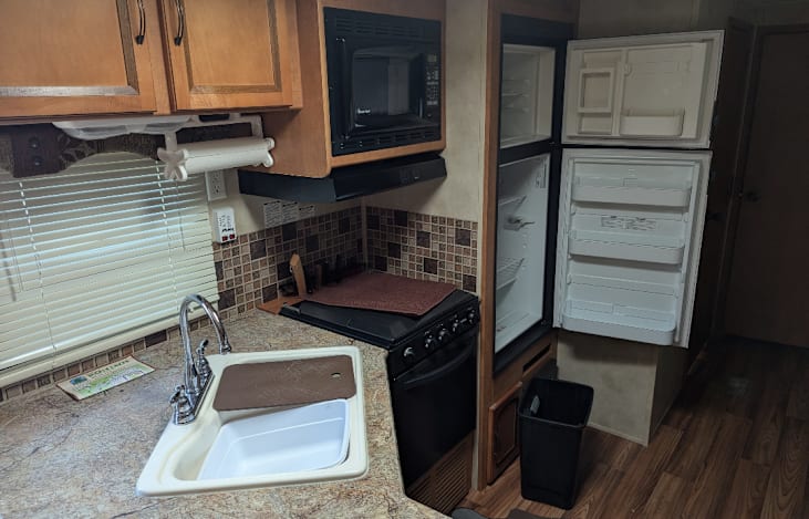 Kitchen with stove, oven, microwave, refrigerator, freezer and double sink.