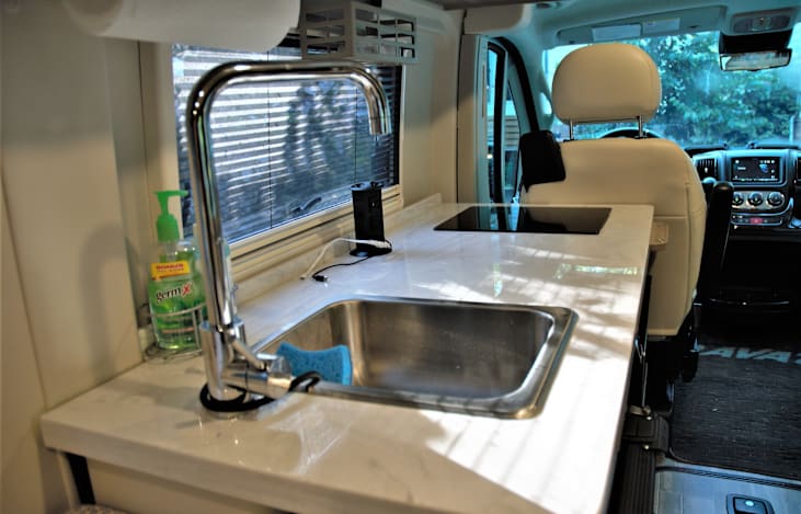 Kitchen counter top equipped with sink, stove top, and a charging tower with 2 outlets and USB ports.
