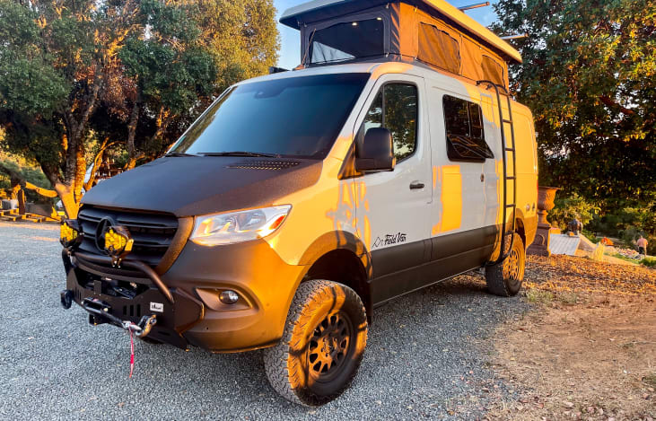 This is a Field Van Mercedes-Benz Sprinter 144 4x4 with a motorized pop-top. It can fit in a normal parking space, yet expands to sleep four adults.