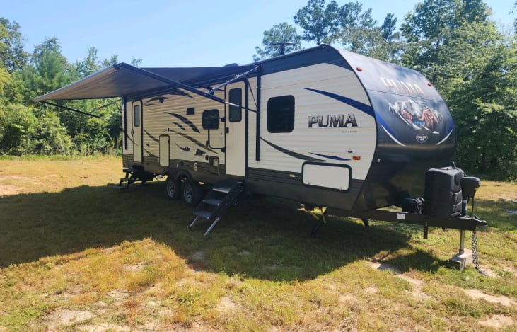 Extended canopy, outside fridge, comfortable chairs and portable grill located in the storage compartment.